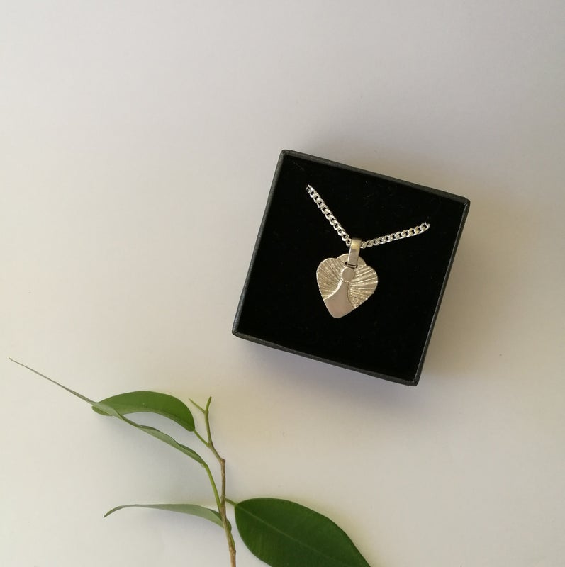 Syd&auml;nenkeli-riipus ketjulla, rasiassa.